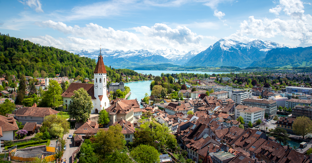 Aerial view of the medieval city of Thun in Switzerland's Bernese Oberland with a lake and snow-capped mountains in the background